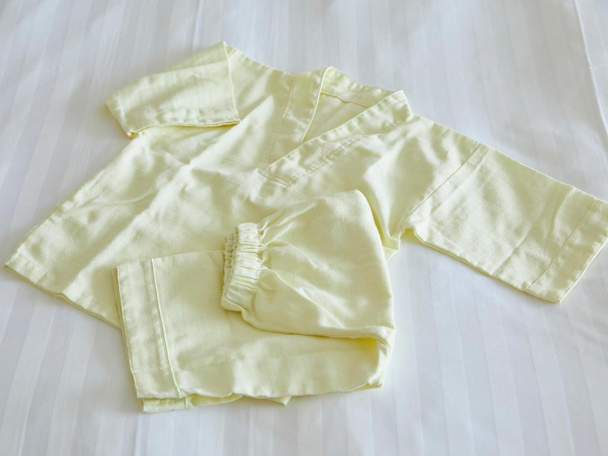 Готель Grand Nikko Tokyo Bay Maihama Urayasu Екстер'єр фото The photo shows a small, traditional outfit made of light yellow fabric. The outfit includes a short-sleeved top with a V-neck and a pair of matching pants. The design is simple, featuring a loose fit and a comfortable style, making it suitable for c