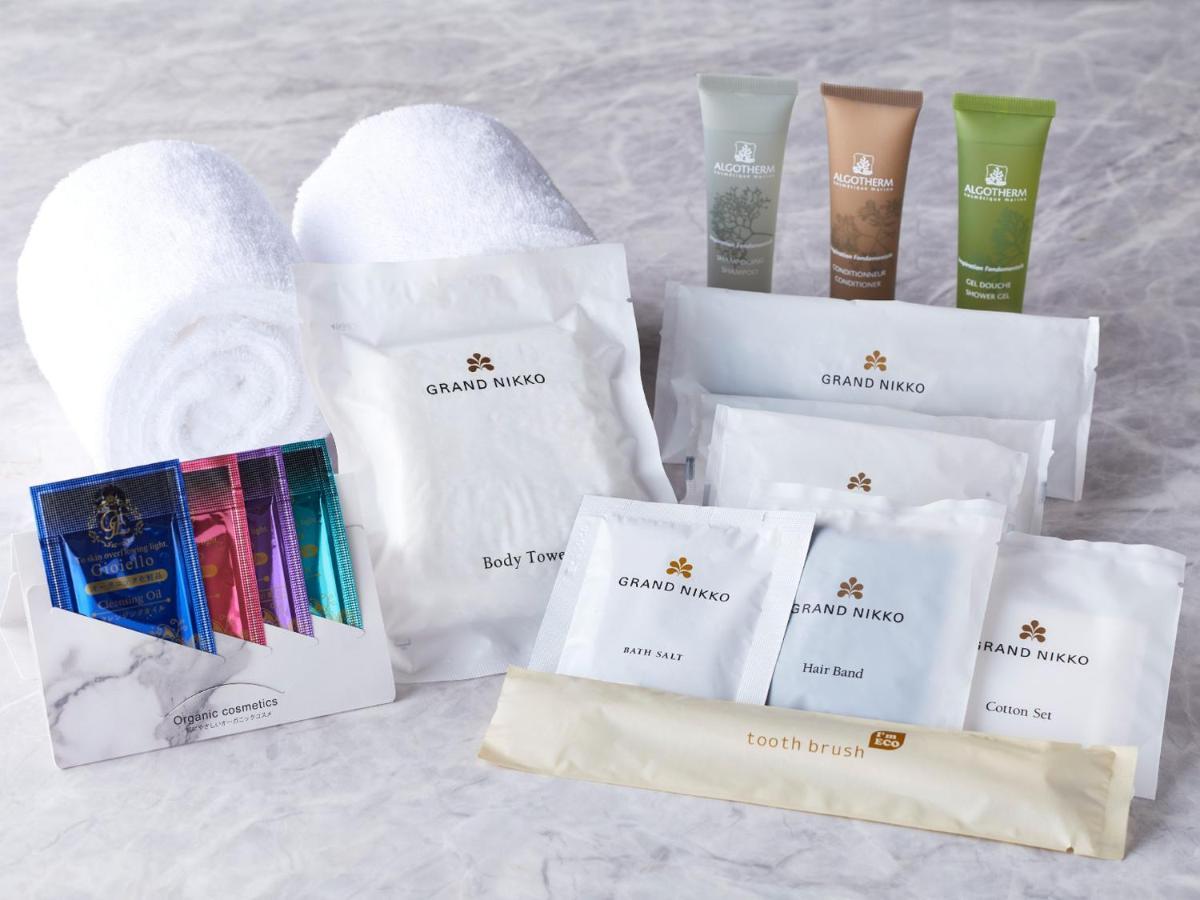 Готель Grand Nikko Tokyo Bay Maihama Urayasu Екстер'єр фото The photo displays a collection of spa or hotel toiletries. It includes:

- Two fluffy white towels.
- Multiple packages labeled "GRAND NAKO," which appear to be spa or body care products.
- Several small tubes of hair and body care items in green an