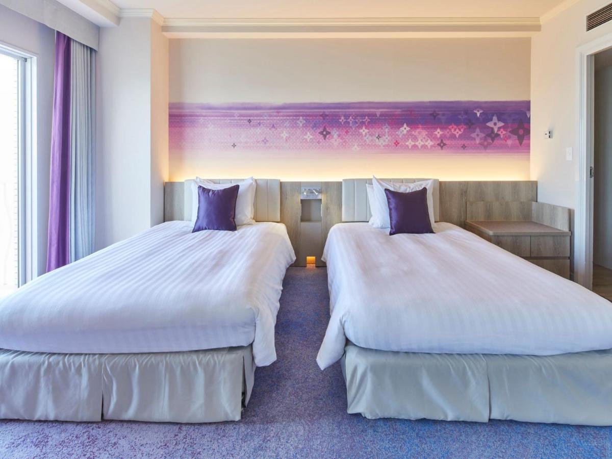 Готель Grand Nikko Tokyo Bay Maihama Urayasu Екстер'єр фото The photo shows a hotel room featuring two twin beds with white bedding and purple accent pillows. The beds are positioned next to each other, with a light-colored headboard. Behind the beds, there is a decorative wall with a gradient of purple hues.