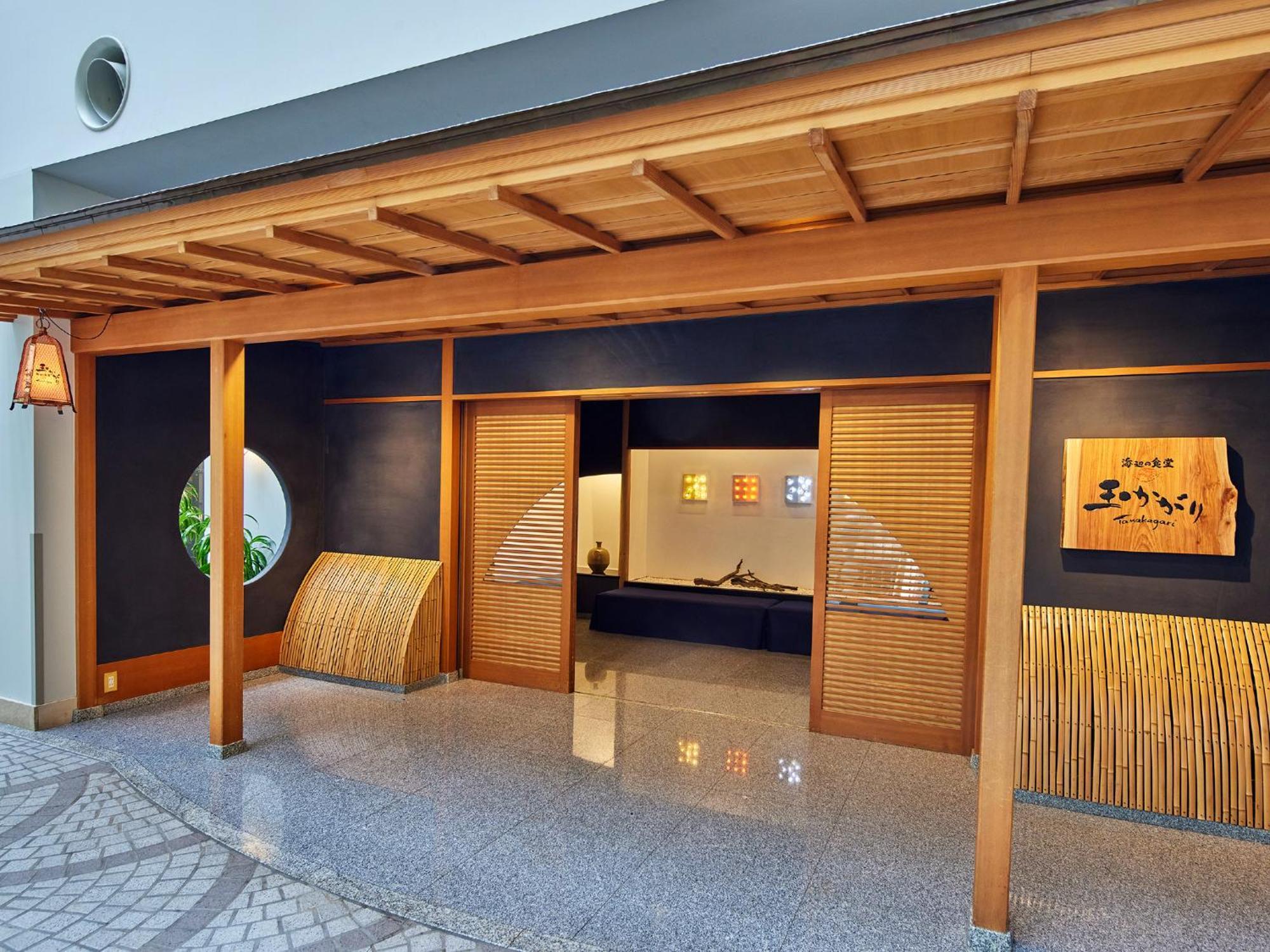 Готель Grand Nikko Tokyo Bay Maihama Urayasu Екстер'єр фото The photo shows the entrance of a building, designed in a traditional Japanese style. It features a wooden structure with a large overhanging roof and sliding doors. The entrance is flanked by rounded windows, and there's a decorative sign with Japan