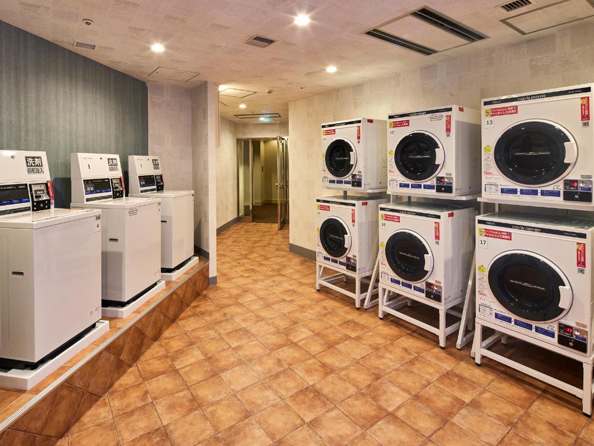 Готель Grand Nikko Tokyo Bay Maihama Urayasu Екстер'єр фото The photo shows a laundry room with several washing machines and dryers. On the left side, there are five white washing machines, and on the right side, there are four dryers. The machines are arranged in a clean, tiled space with a neutral-colored w